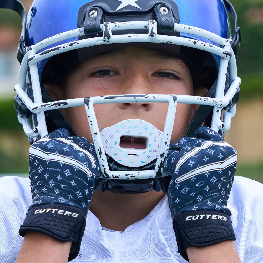 Lifestyle Image of Youth Football Player Wearing Black/White Lux Rev 5.0 Limited-Edition Youth Receiver Gloves