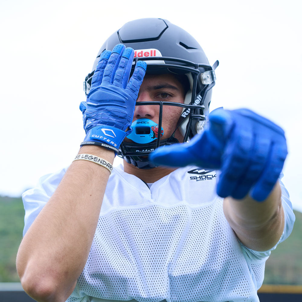 Lifestyle Detail Shot of Football Player Wearing Cutters Gamer 5.0 Padded Receiver Gloves in Royal Blue