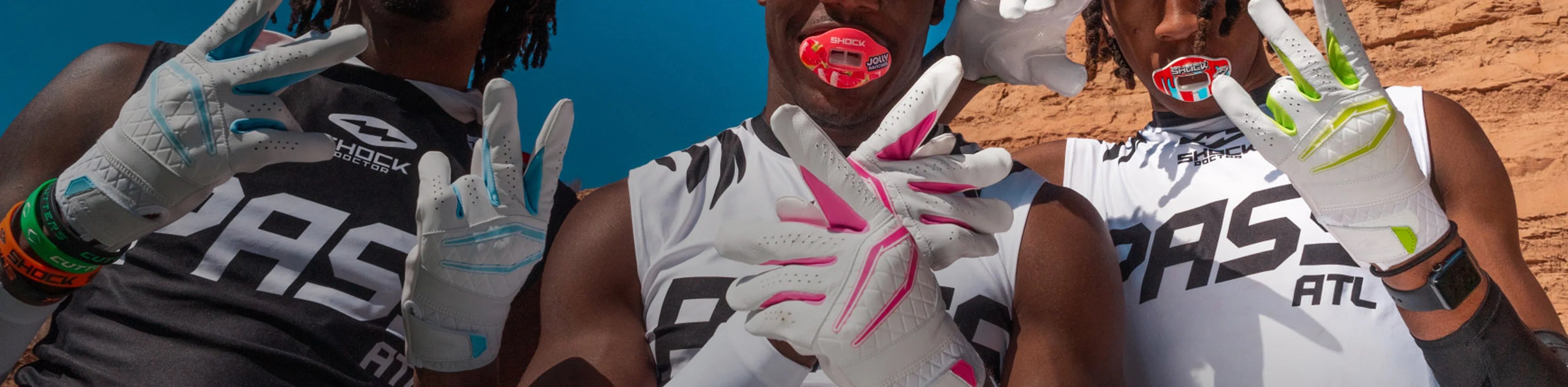 Header image for the 'New Releases' Collection by Cutters Sports. Three football athletes pose in white receiver gloves and Shock Doctor mouthguards, flashing hand signs in front of a red rock backdrop, showcasing fresh football gear drops.