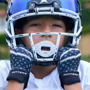 Lifestyle Image of Youth Football Player Wearing Black/White Lux Rev 5.0 Limited-Edition Youth Receiver Gloves