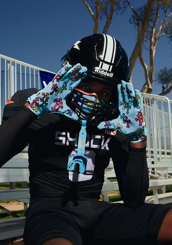 Person wearing a black helmet and colorful gloves with a blue 'SHOCK' logo.