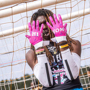 Rev Pro 5.0 Hi Mom LE Football Receiver Gloves by Cutters Sports in vibrant pink with 'HI MOM' text, worn by a football player on the field.