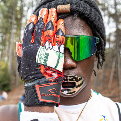 Lifestyle Image of Youth 7v7 Football Player Wearing Cutters Sports Money Mouth Rev Pro 5.0 Limited-Edition Receiver Football Gloves