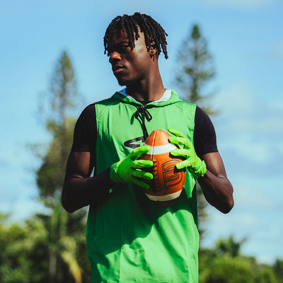 Youth 7v7 Football Athlete Wearing Cutters Sports Rev Pro 6.0 Solid Receiver Football Gloves in Shock Green